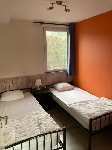 2 camas en una habitación con ventana en La Bergerie de Ster, en Francorchamps