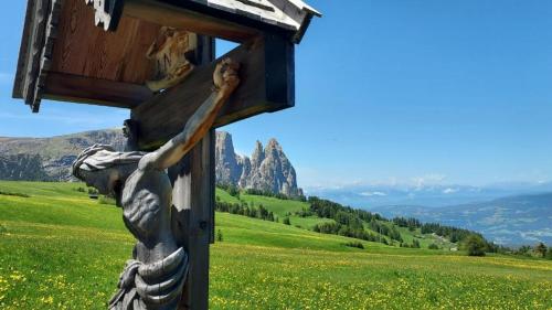 une statue d'une personne arrivant dans une boîte en bois dans l'établissement Relax Home Fie' allo Sciliar - Alpe di Siusi Val Gardena, à Fiè