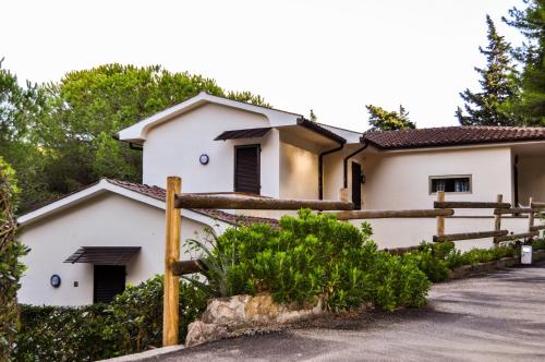 a white house with a wooden fence at Residence Le Mimose in Procchio