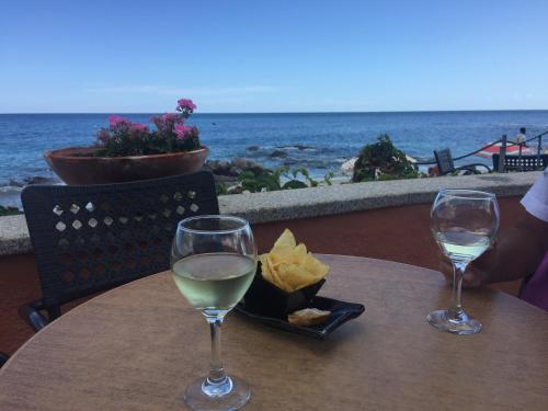 una mesa con dos copas de vino blanco y patatas fritas en Appartamento Panorama 1, en San Teodoro