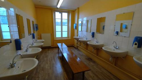 uma casa de banho com um monte de lavatórios e espelhos em Hostellerie des Grands Chapeaux em Bayeux
