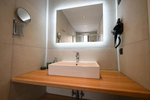 a bathroom with a white sink and a mirror at CUBES ON THE BEACH Athens Airport in Artemida