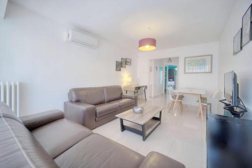 un salon avec un canapé et une table dans l'établissement IMMOGROOM - Renovated apartment - Terrace - AC, à Cannes