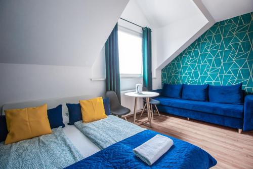 a living room with a blue couch and a blue bed at WillaMaks in Ustka