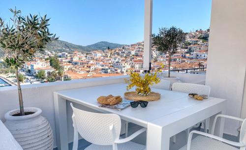 a white table and chairs with a view of a city at Gigi Rooms in Poros