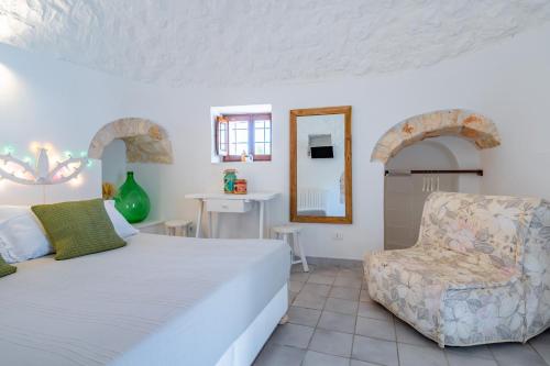 ein Schlafzimmer mit einem Bett, einem Stuhl und einem Spiegel in der Unterkunft Dimora Rutica in Selva di Fasano