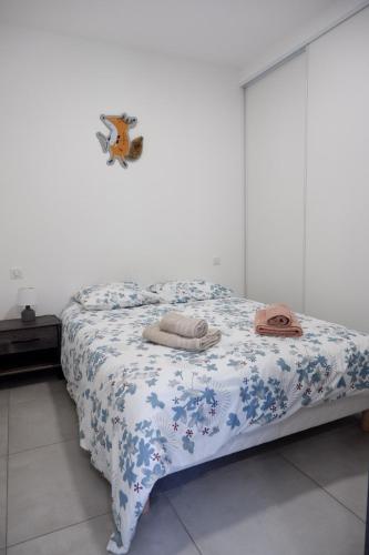 une chambre avec un lit avec une couverture bleue et blanche dans l'établissement N7 Maison T2 climatisé avec jacuzzi privé, à Ajaccio