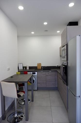 une cuisine avec un réfrigérateur en acier inoxydable et une table dans l'établissement N7 Maison T2 climatisé avec jacuzzi privé, à Ajaccio