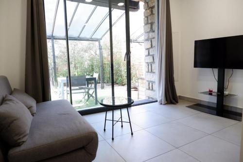 salon z kanapą i dużym oknem w obiekcie N7 Maison T2 climatisé avec jacuzzi privé w Ajaccio