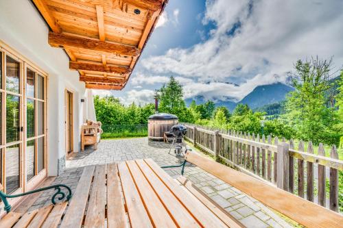 a wooden deck with a wooden bench and a wooden fence at Chaletdorf am Sonnenhang in Neukirchen am Großvenediger