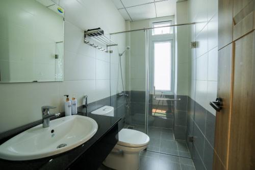 y baño con lavabo, aseo y ducha. en Quang Minh Dalat Hotel, en Da Lat