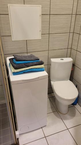 a bathroom with a toilet and towels on top of it at Kiviõli Apartment in Kiviõli