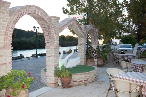 an archway with two swans in the middle of a patio at Hotel Glaros in Ammoudia