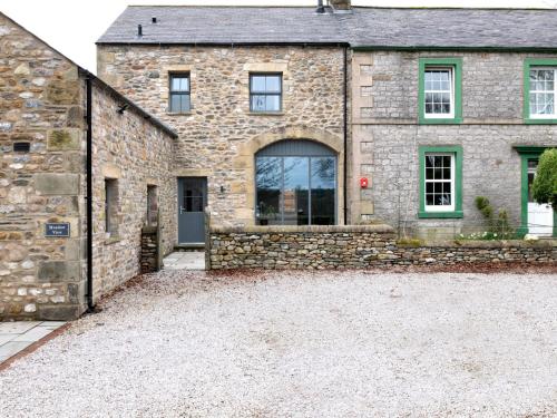 a stone house with a driveway in front of it at Meadow View Cottage in Carnforth