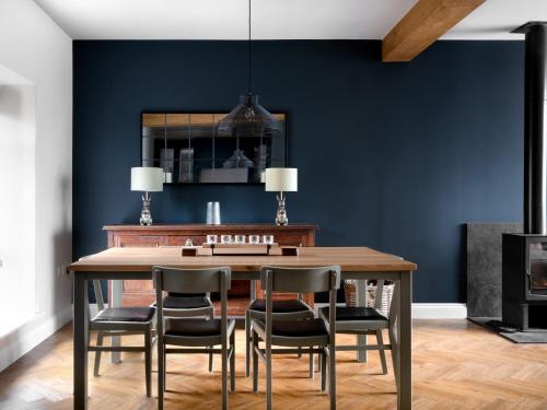 a dining room with blue walls and a wooden table and chairs at Meadow View Cottage in Carnforth