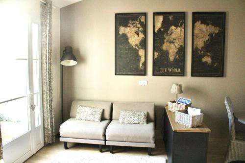 a living room with a couch and maps on the wall at Fleur de Ré in Loix