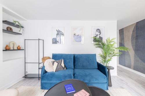 - un canapé bleu dans le salon avec une table dans l'établissement Lovely and cosy apartment 4P1BR, à Paris