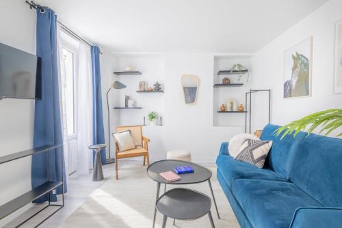 - un salon avec un canapé bleu et une table dans l'établissement Lovely and cosy apartment 4P1BR, à Paris