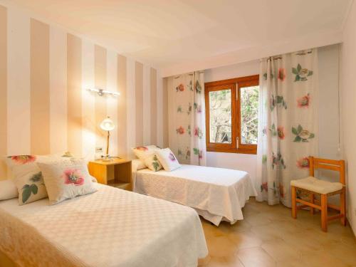 a bedroom with two beds and a window at Bugambilla in Playa de Muro