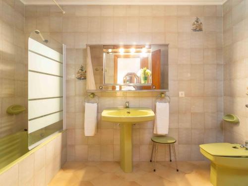a bathroom with a yellow sink and a mirror at Bugambilla in Playa de Muro