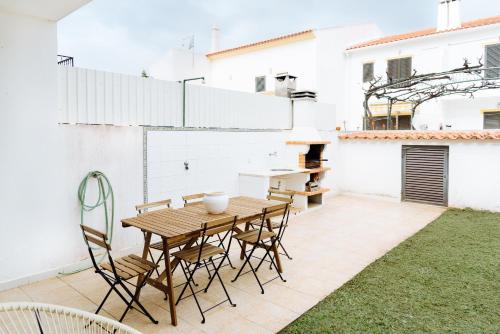 a patio with a wooden table and chairs at Altura Beach Villa by GT House in Altura