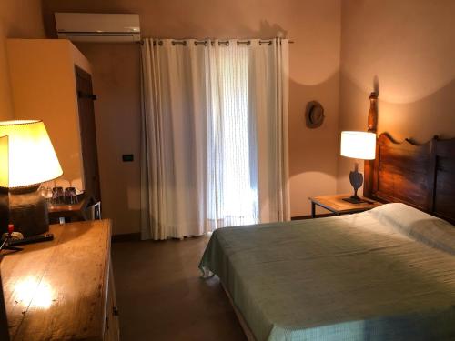 um quarto com uma cama, um candeeiro e uma janela em Cave Garden villa em Favignana