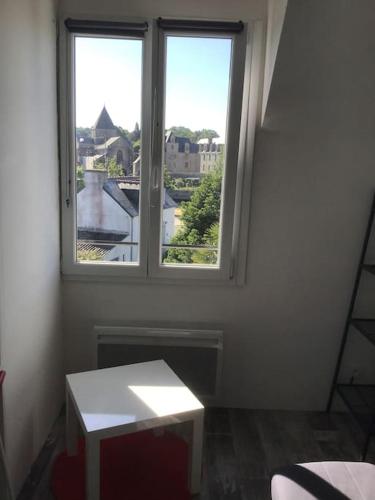 a white room with two windows and a table at Studio au centre de Quimper 2ème ET in Quimper