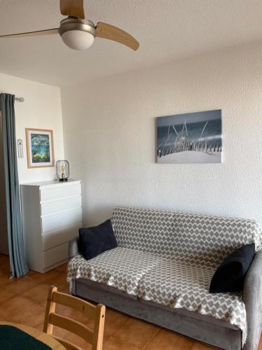 - un salon avec un canapé et un ventilateur de plafond dans l'établissement L’azur, au Lavandou