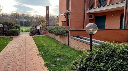 un trottoir à côté d'un bâtiment en briques avec un éclairage de rue dans l'établissement Parco della danza, à Reggio d'Émilie
