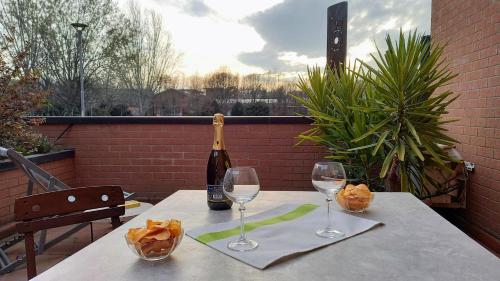 einen Tisch mit einer Flasche Wein und zwei Weingläsern in der Unterkunft Parco della danza in Reggio nell'Emilia