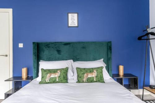 a blue bedroom with a bed with two deer pillows at Modern Complete Cotham House #2 by Prescott Apartments in Bristol