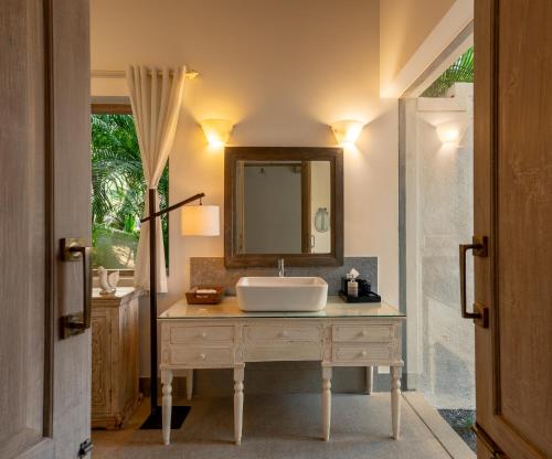 a bathroom with a sink and a mirror at ama Stays & Trails 70 Vale, Goa in Vagator