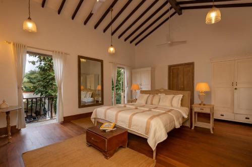 a bedroom with a large bed and a large window at ama Stays & Trails 70 Vale, Goa in Vagator