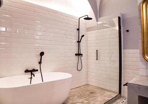 a white bathroom with a tub and a shower at Casa Rural Casa Levante in Arcos de la Frontera