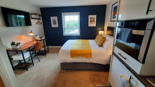 een slaapkamer met een bed, een bureau en een keuken bij Deva Leisure in Chester