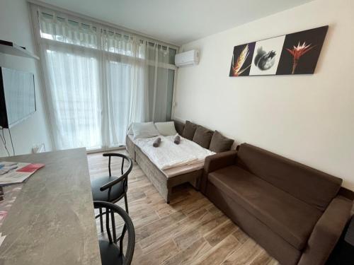 ein Wohnzimmer mit einem Sofa und einem Tisch in der Unterkunft Violett Apartman in Balatonberény