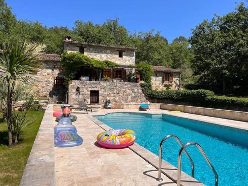 una piscina con gonfiabili di fronte a una casa di Magnifique villa en pierre au calme absolu a Fayence