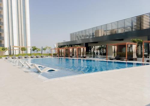 a large swimming pool in front of a building at Nasma Luxury Stays - Harbour Gate Tower 1 in Dubai
