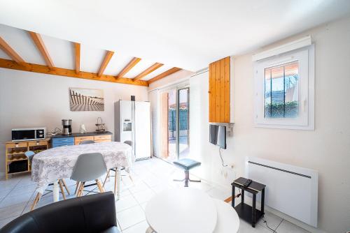 une cuisine et un salon avec une table et des chaises dans l'établissement Soleil des Acacias - Climatisé et proche plage, à Argelès-sur-Mer