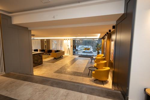 a hallway with yellow chairs and a living room at Hotel Schlangenbader Hof in Schlangenbad