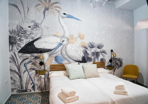 una camera da letto con un letto con uccelli sul muro di Casa Rural Casa Levante ad Arcos de la Frontera