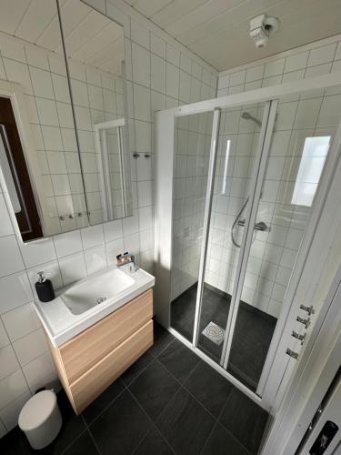 a white bathroom with a sink and a shower at Norsk Havbrukssenter - Rorbuer in Brønnøysund