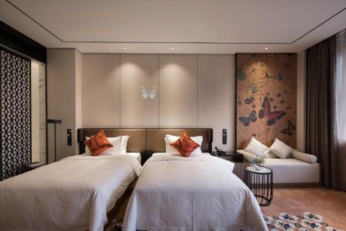 a hotel room with two beds and a couch at Paco Hotel Dongpu Guanghzou -Free Shuttle Bus for Canton Fair in Guangzhou