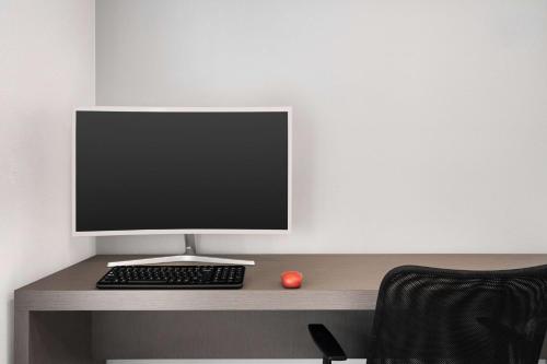 a computer monitor and a keyboard and mouse on a desk at Ramada by Wyndham Anaheim Convention Center in Anaheim