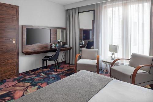 クラクフにあるINX デザイン ホテルのベッド1台、薄型テレビが備わるホテルルームです。