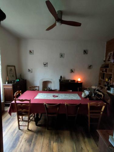 une salle à manger avec une table rose et un ventilateur de plafond dans l'établissement Ty Merzhin, à Huelgoat