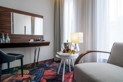 a hotel room with a table and a mirror at INX Design Hotel in Kraków