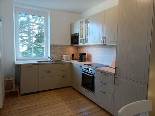 a kitchen with white cabinets and a window at Ferienwohnung Gasthof Port - a84059 in Naunheim