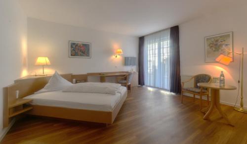 a bedroom with a bed and a table and a desk at Apartment 4 in Braunsbach