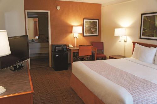 a hotel room with a bed and a desk with a television at Baymont by Wyndham San Antonio South Park in San Antonio